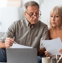 senior couple reading bills at home