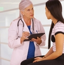 doctor holding tablet checking young girl 