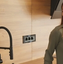 Woman drinking purified water from kitchen faucet