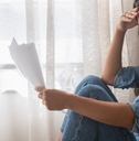 stressed woman holding financial papers