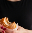 female hands holding fast food burger