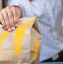 McDonald's worker holding fast food bag