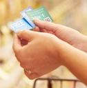 woman in supermarket with coupons