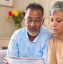 senior couple reviewing bills using laptop