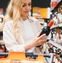 girl chooses wine in supermarket