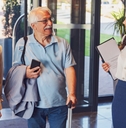 cheerful hotel receptionist greeting senior couple