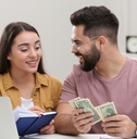 young couple counting money at home