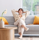 happy woman relaxing on grey sofa