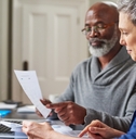 retired couple reviewing monthly budget 