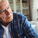 Worried senior man sitting on a sofa
