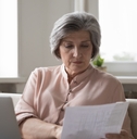 senior female accountant checking paper invoices