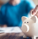 woman putting money in piggy bank