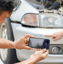 A man takes a picture of a car accident.