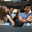A group of friends drive in a car together.