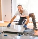 Handyman installing tile on floor
