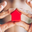 woman holding miniature house sculpture property concept