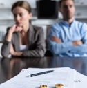 unhappy couple at table with divorce documents