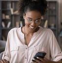 A woman looks at her phone at home. 