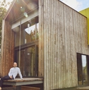 senior man with beer sitting outside house