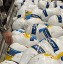 shopper is choosing a turkey in grocery store