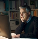 senior man working from home late night