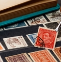 philatelist holds the postage stamp