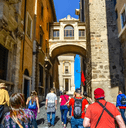 A group of unidentifiable tourists follow a tour guide in Rome