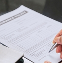 senior man signing life insurance form 