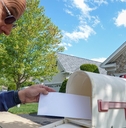 taking white envelope from letterbox