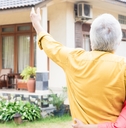 elderly man pointing to a house