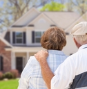 retired senior couple looking at house 