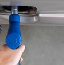 Hand holding blue gas pump nozzle