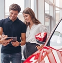 signing papers in card dealership