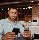 a man smiles while holding his credit card