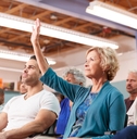 Woman Asking Question At Neighborhood Meeting In Community Center 