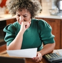 woman reviews paperwork at her kitchen