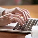 Mature female person typing text on keyboard