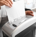 secretary destroying paper sheet using shredder in office
