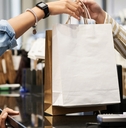 cashier giving paper bags with purchases