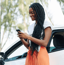 person on phone outside car
