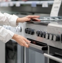 woman buying a new kitchen stove in the electronics retail store