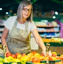 store worker lays out and sorts fruit