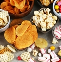 Salty snacks. Pretzels, chips, crackers and candy sweets on table 