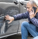 Man looking at car damage