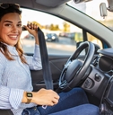 Smiling woman buckling a seatbelt