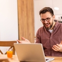 Smiling man working from home on a laptop