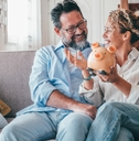 caucasian couple holding piggy bank
