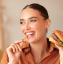 Happy lady eating burger and french fries