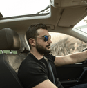 mid-30s person driving car