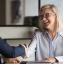 businesswoman shaking hands with younger business colleague